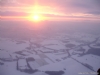 Zonsopgang boven een sneeuwlandschap.